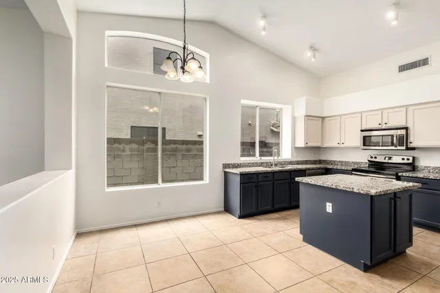 a large kitchen with a stove top oven a sink a counter space and cabinets