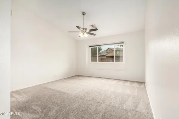 an empty room with a window and a ceiling fan