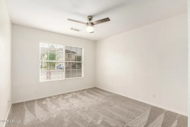 an empty room with ceiling fan and window