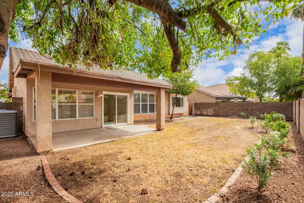 front view of a house with a large window and covered with trees
