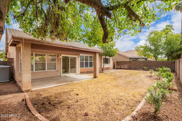 front view of a house with a large window and covered with trees
