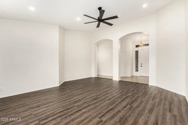 a view of empty room with wooden floor and ceiling fan
