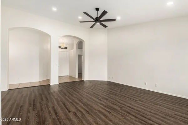 a view of an empty room with a window and a ceiling fan