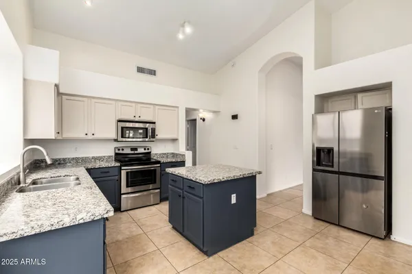 a kitchen with stainless steel appliances granite countertop a stove refrigerator and sink