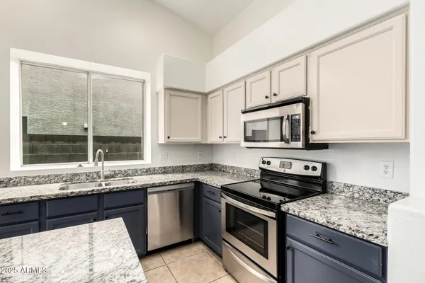a kitchen with stainless steel appliances granite countertop a sink stove and microwave
