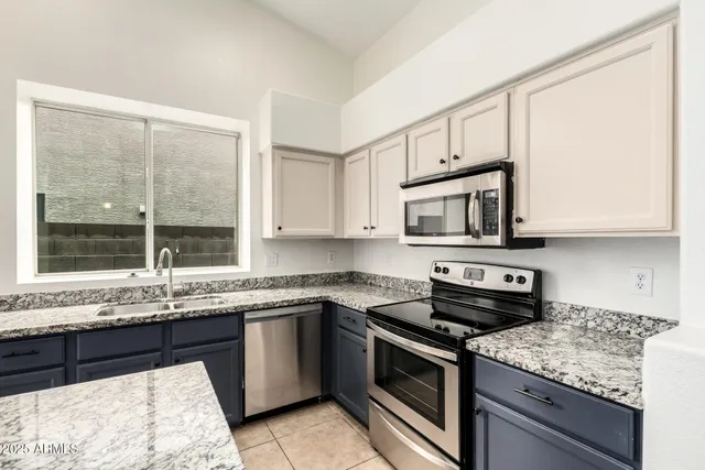 a kitchen with stainless steel appliances granite countertop a sink stove and microwave