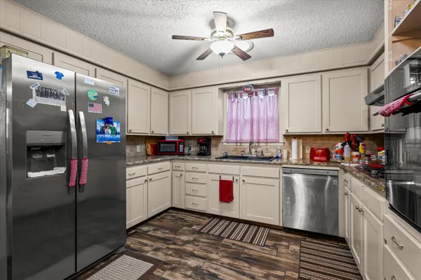 a kitchen with stainless steel appliances granite countertop a sink and cabinets