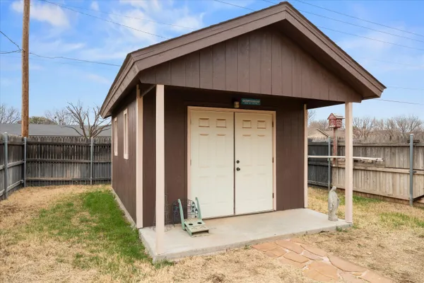 a backyard of a house with barbeque oven and seating space
