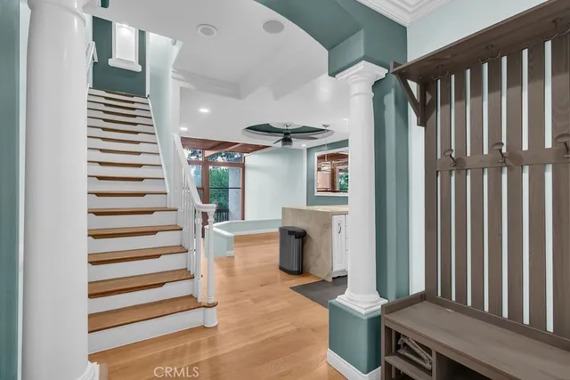 a room with lots of white furniture and wooden floor