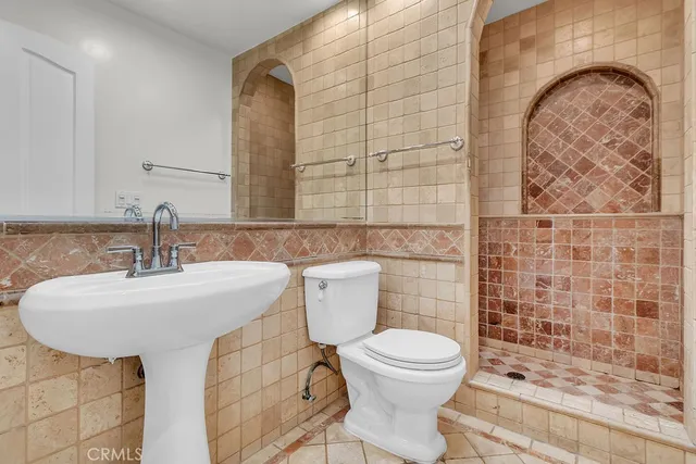 a bathroom with a sink a toilet and shower