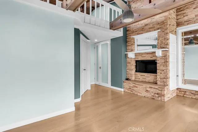 a view of a livingroom with wooden floor and a ceiling fan
