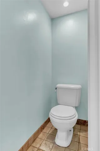 a white toilet sitting next to a white wall