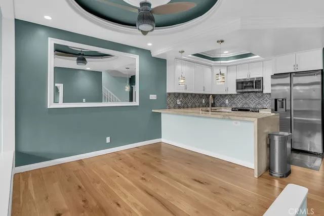 a kitchen with kitchen island stainless steel appliances a sink and cabinets