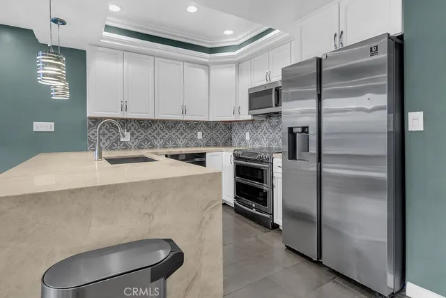 a kitchen with stainless steel appliances a refrigerator sink and stove