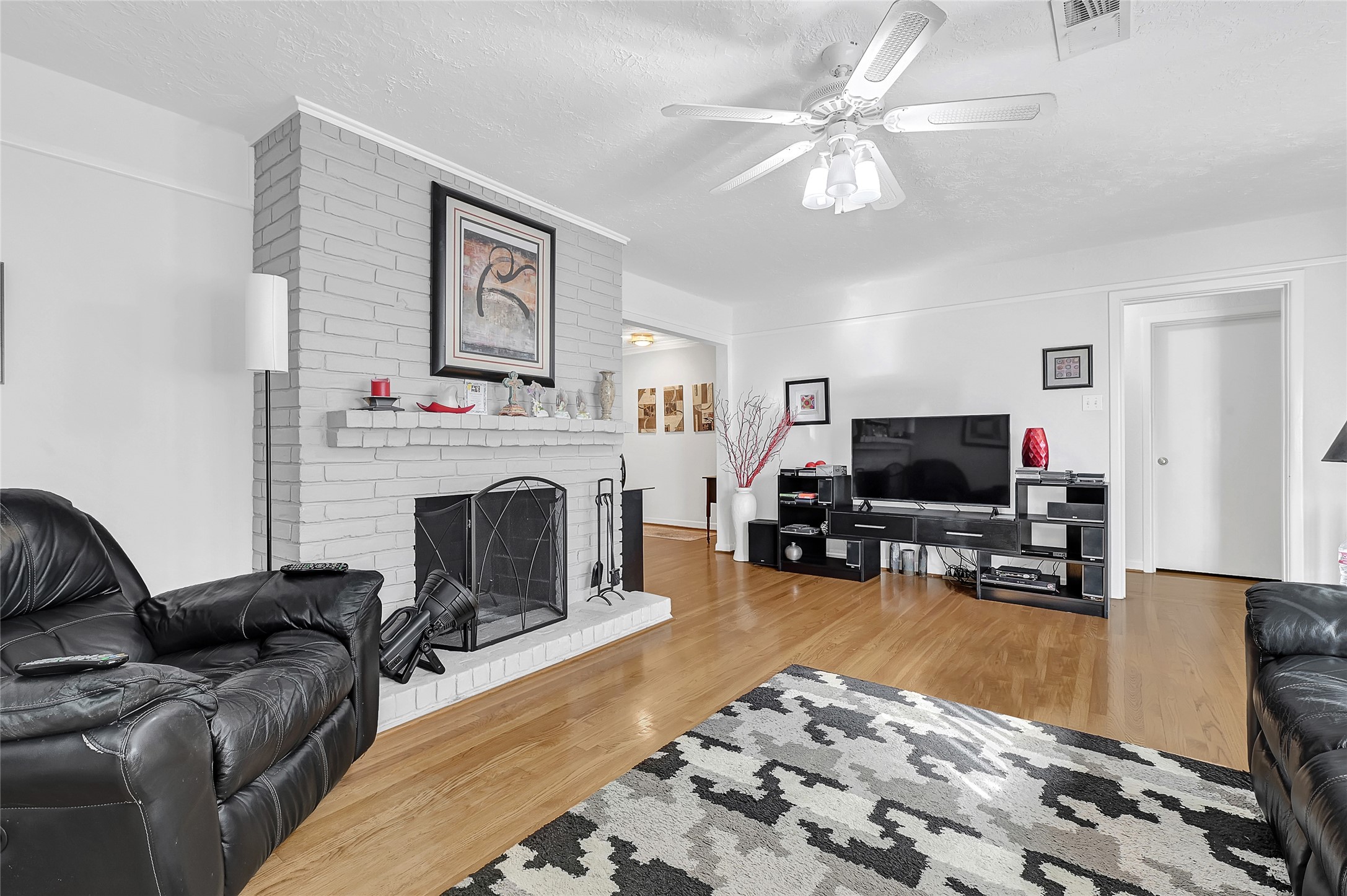 4831 Knickerbocker Street Houston, TX 77035 - Photo 18 of 50 a living room with furniture a fireplace and a flat screen tv