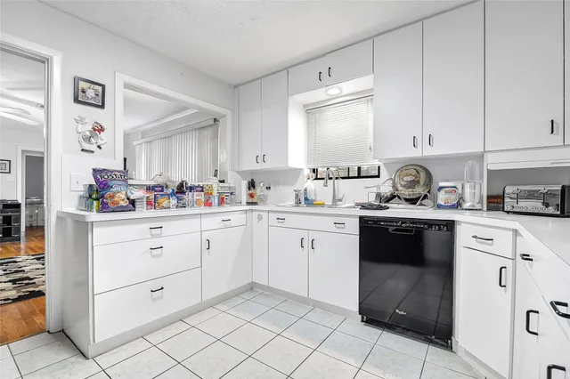 a kitchen with white cabinets appliances and a sink