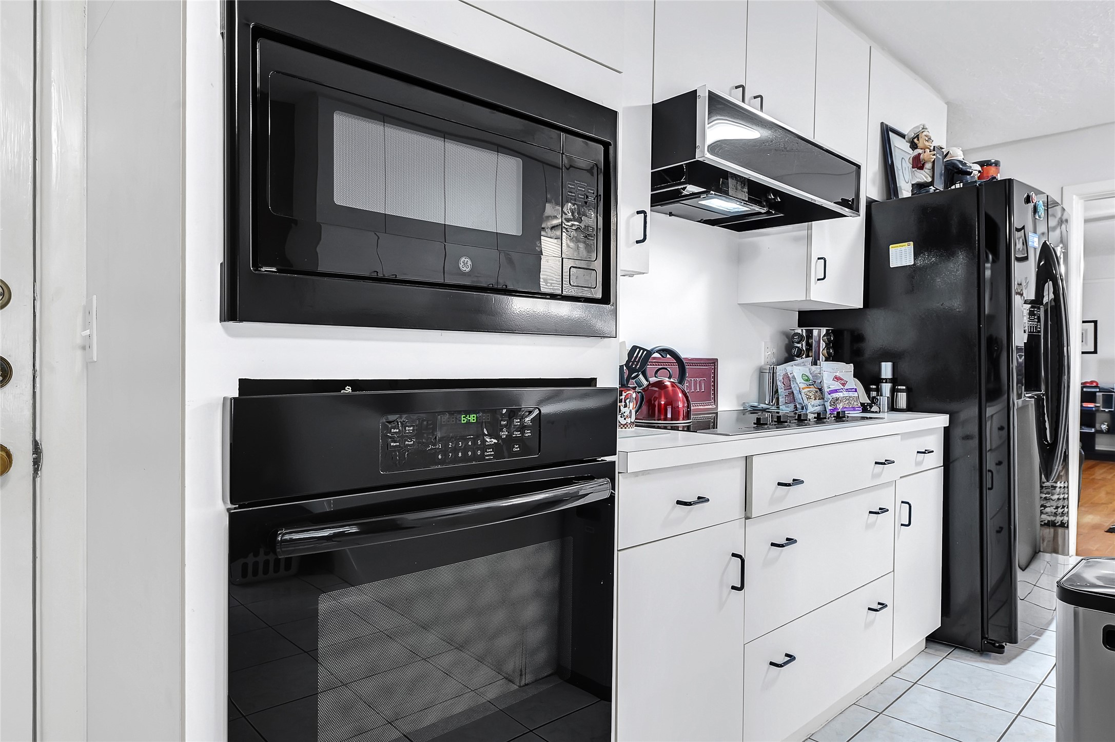 4831 Knickerbocker Street Houston, TX 77035 - Photo 27 of 50 a kitchen with white cabinets and black appliances