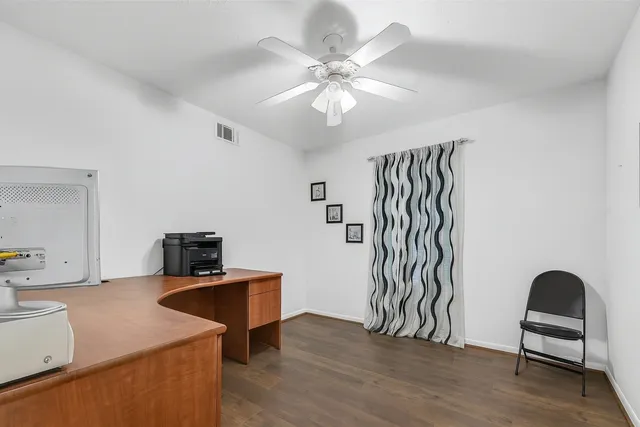 a view of a workspace with furniture and wooden floor