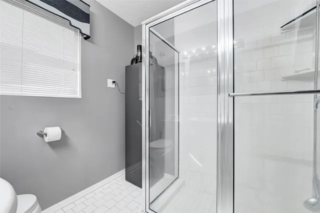 a bathroom with a granite countertop shower and a toilet