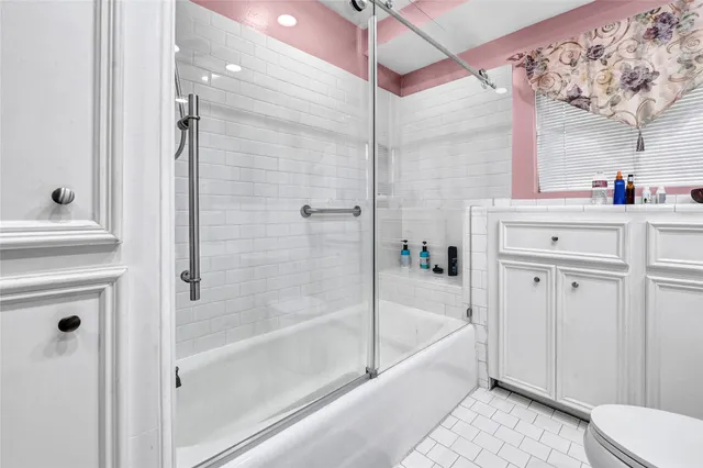 a bathroom with a bathtub shower sink vanity and toilet