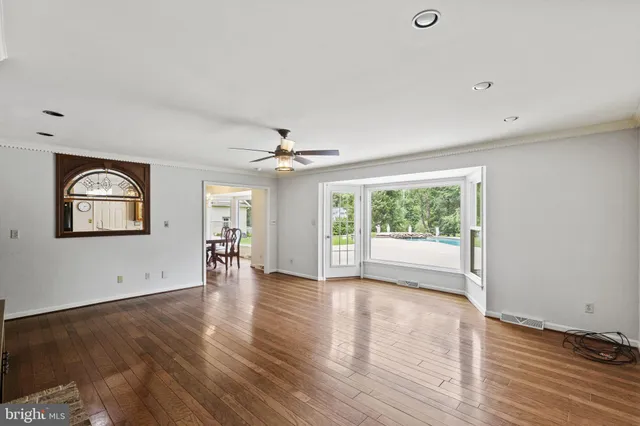 a view of an empty room with a sliding door and wooden floor