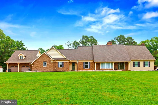 a view of a big house with a big yard and large trees