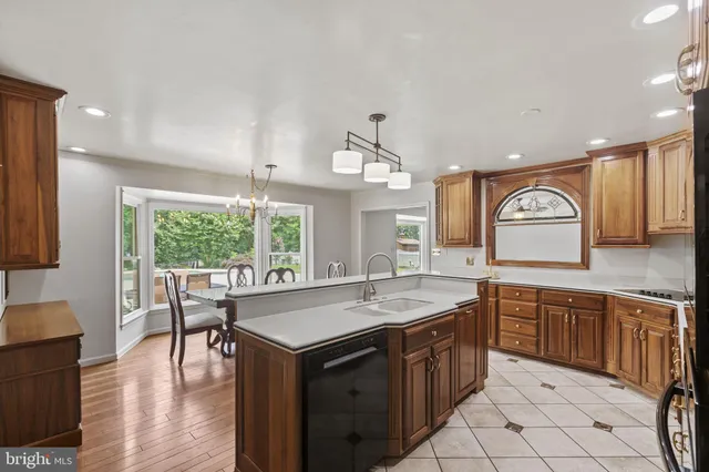 a kitchen with stainless steel appliances granite countertop a refrigerator a stove a sink dishwasher with a dining table and chairs with wooden floor
