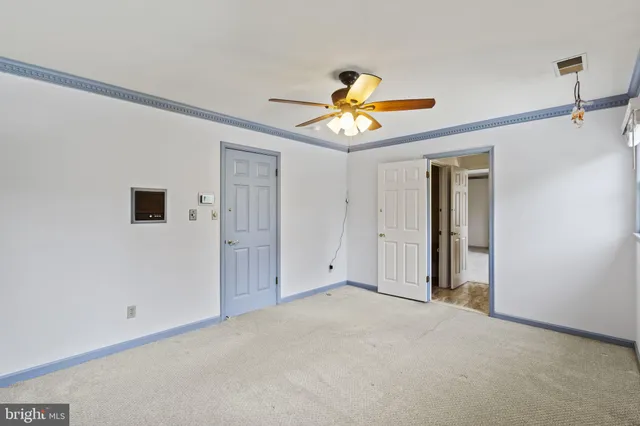 a view of empty room with wooden floor and windows
