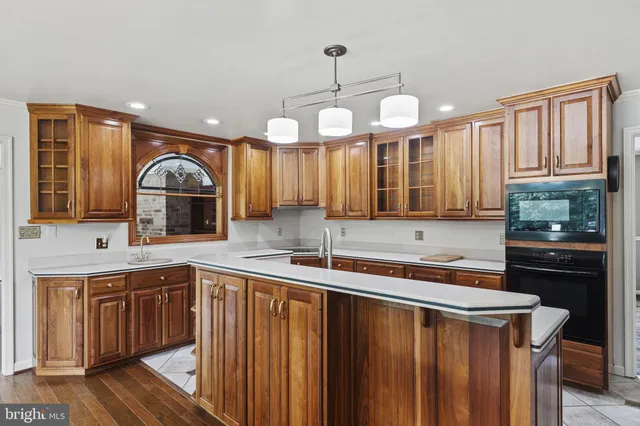 a kitchen with granite countertop a refrigerator and a stove top oven