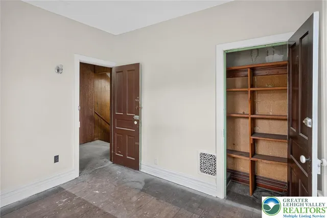 an empty room with windows and closet