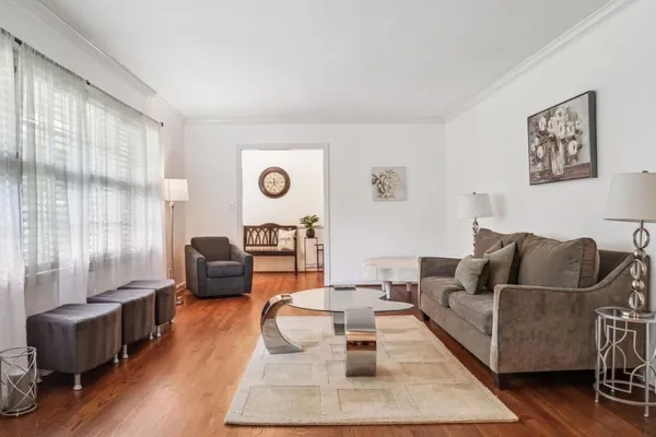 a living room with furniture wooden floor and large window