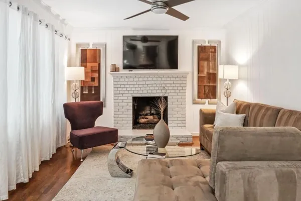 a living room with furniture a flat screen tv and a fireplace