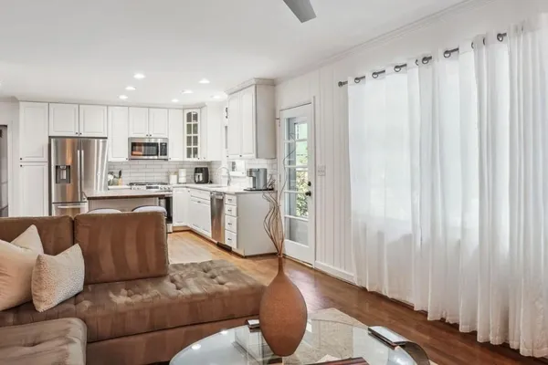 a living room with furniture and a kitchen