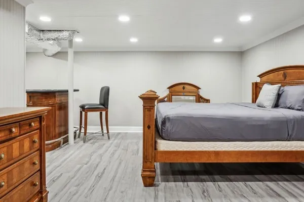 a bedroom with a bed and a potted plant on dresser