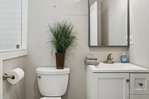 a bathroom with a toilet a sink and mirror