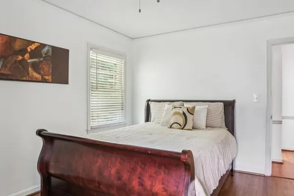 a bedroom with a bed and wooden floor