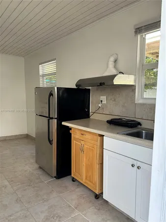 a kitchen with a sink cabinets and a refrigerator