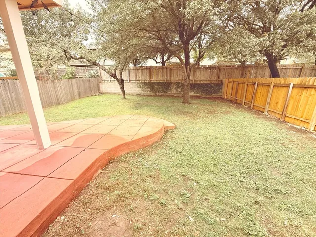 a view of yard with wooden fence