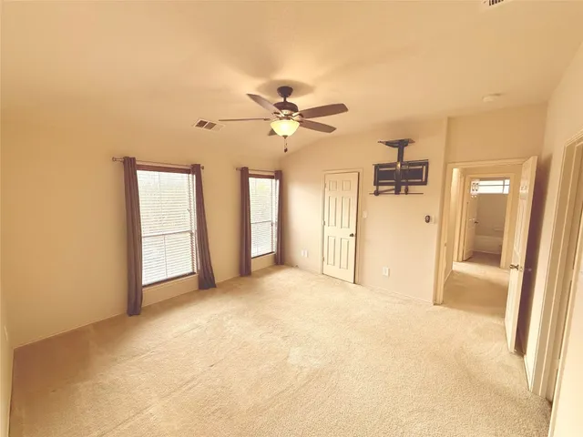 a view of a big room with chandelier fan and windows