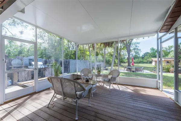 a dining room with wooden floor glass walls and glass doors