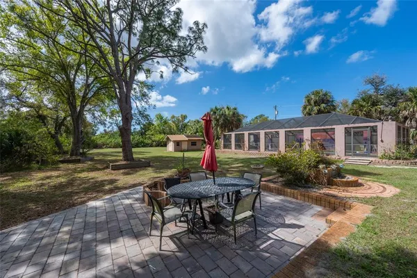 a view of a house with backyard and sitting area