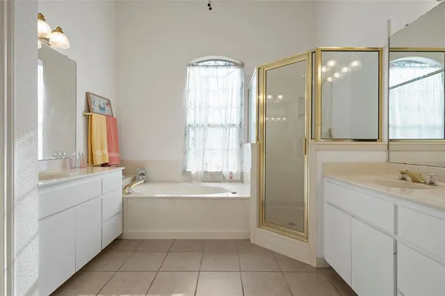 a bathroom with a tub sink shower and mirror