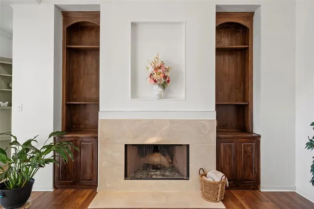 a living room with a fireplace and a potted plant