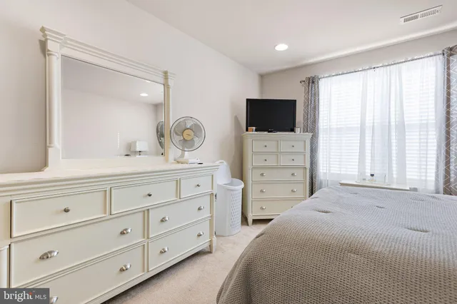 a bedroom with a bed and a mirror on dresser