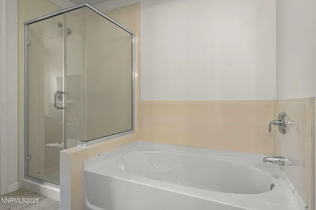 a bathroom with a white bath tub and a shower
