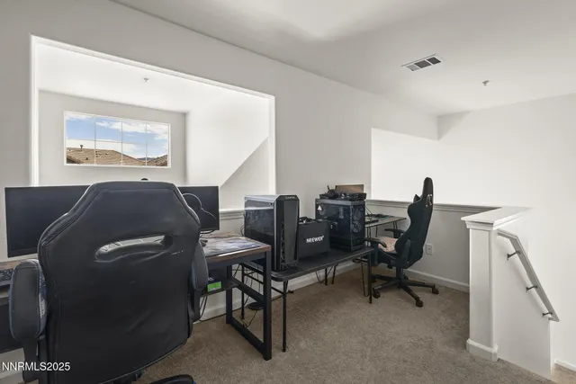 a view of a workspace with furniture and a window