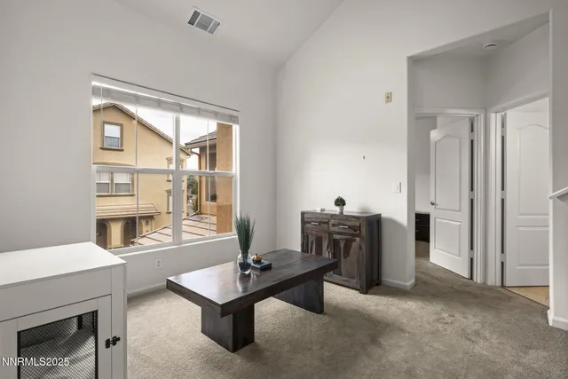 a living room with furniture a table and kitchen view