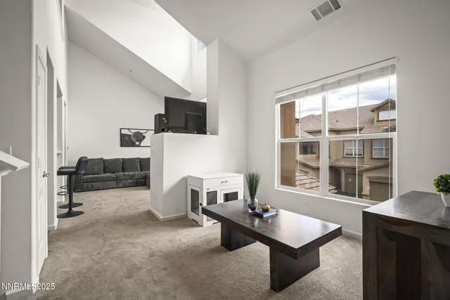 a living room with furniture a flat screen tv and large window