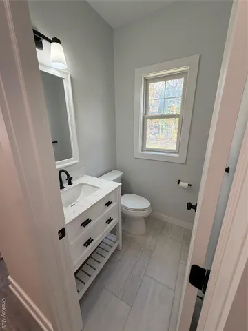 a bathroom with a sink a toilet a mirror and window