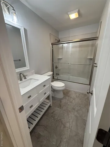 a bathroom with a sink a toilet a mirror and shower